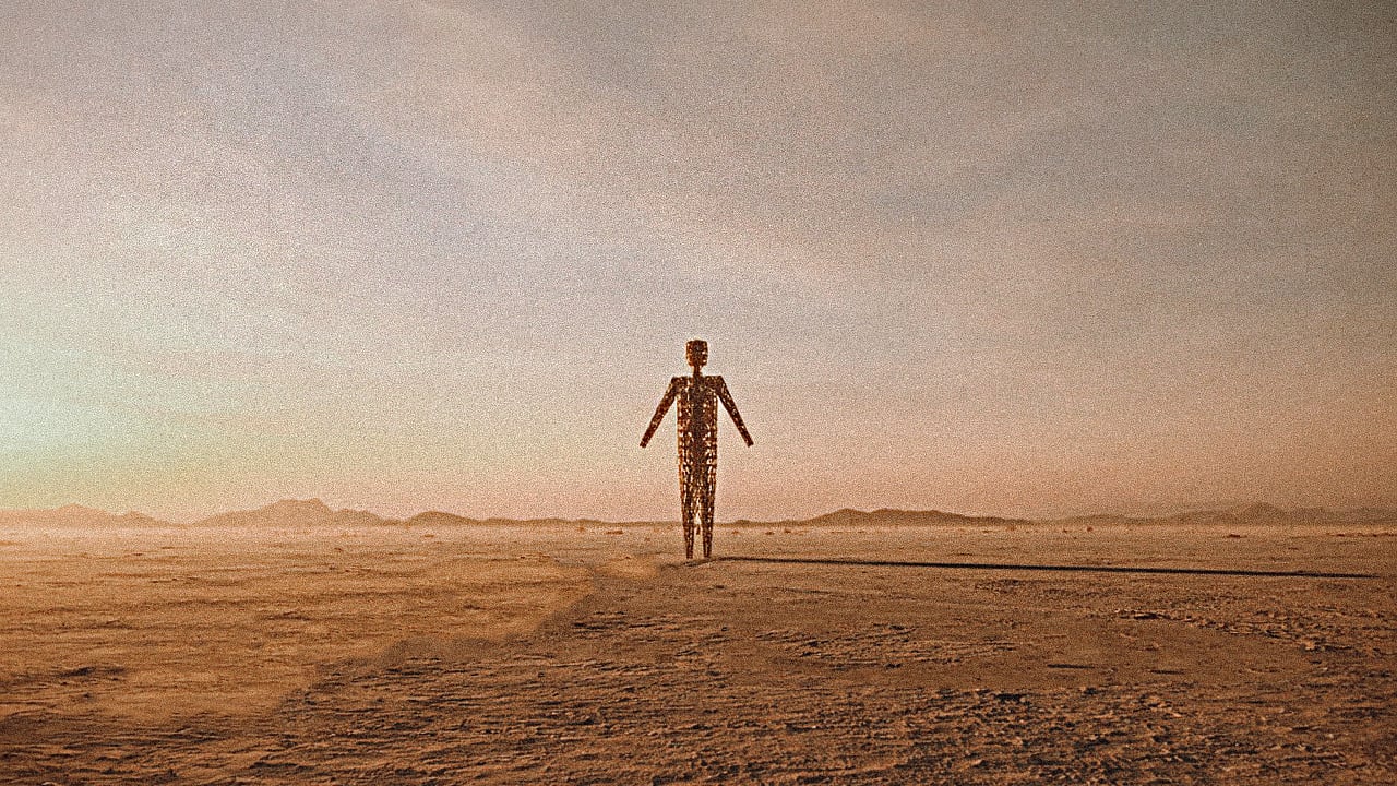Lattice metal sculpture of a lone human figure standing on a wide desert plain under a hazy dusk sky